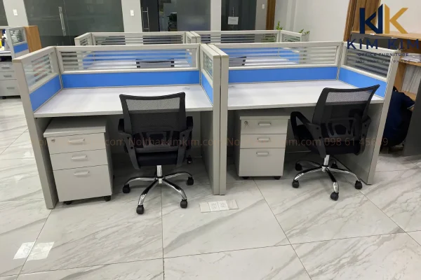 Cụm bàn làm việc có vách ngăn xanh và hộc tủ cá nhân tại văn phòng Công ty 